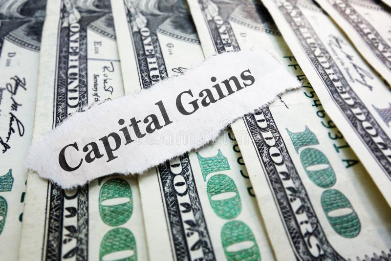 Capital Gains money. Capital Gains newspaper scrap on assorted money stock photo