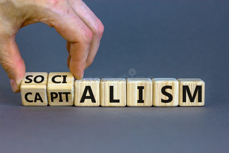 Capitalism or socialism. Hand turns cubes and changes word `capitalism` to `socialism`. Beautiful white background, copy space