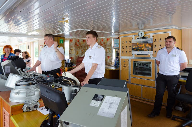 Capitano della nave da crociera Alexander Benois del fiume e degli assistenti del ` s di capitano nella cabina del ` s di capitan fotografia stock libera da diritti