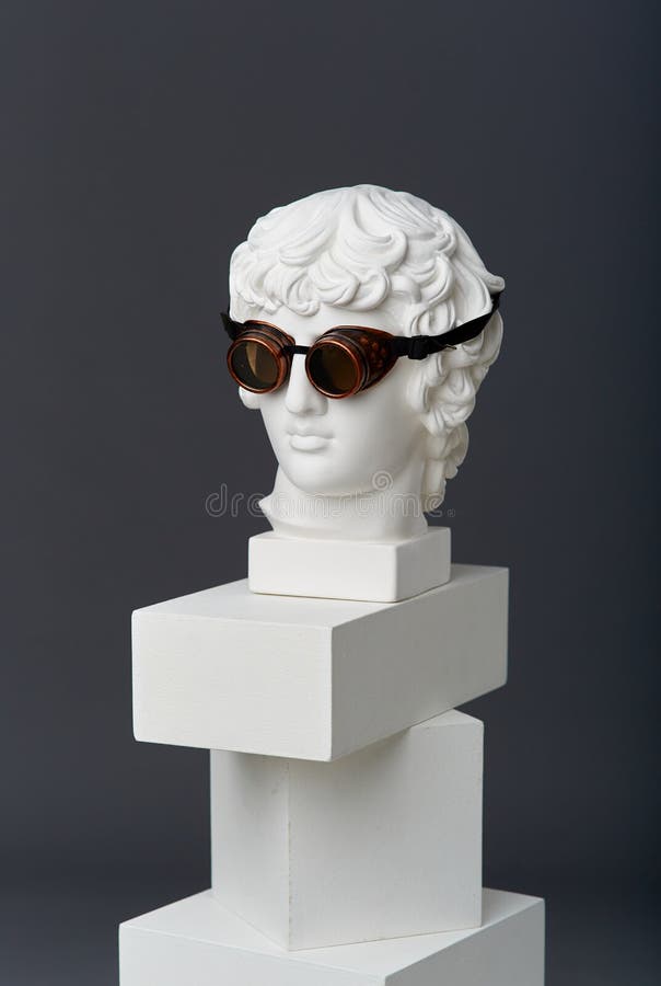 Plaster head of Antinous with round glasses. The concept of the absurd and the combination of the incongruous/. Plaster head of Antinous with round glasses. The concept of the absurd and the combination of the incongruous/