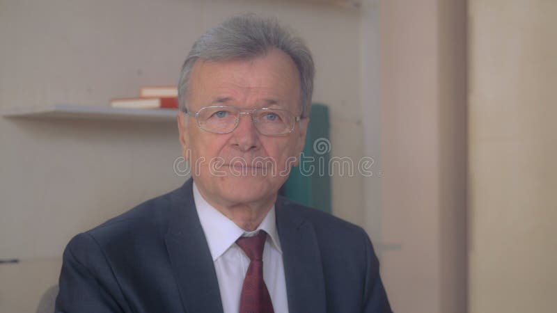 Capo invecchiato che posa all'interno fotografia stock Capo invecchiato che posa all'interno fotografia stock