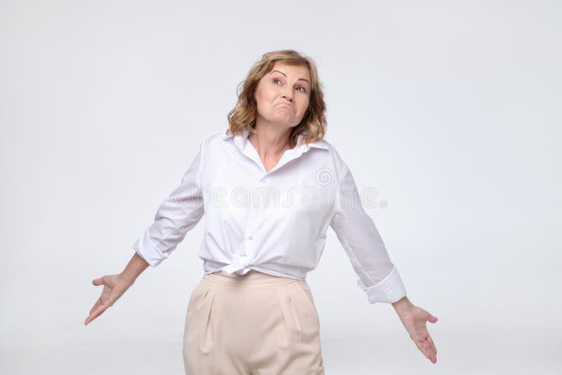 Capo pensionato donna matura graziosa che sembra le scrollate di spalle confuse le sue spalle immagine stock libera da diritti Capo pensionato donna matura graziosa che sembra le scrollate di spalle confuse le sue spalle immagine stock libera da diritti