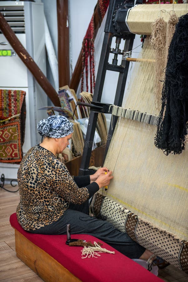 CAPPADOCIA - 17 MAGGIO: Donna che lavora alla fabbricazione di tappeto fotografie stock CAPPADOCIA - 17 MAGGIO: Donna che lavora alla fabbricazione di tappeto fotografie stock