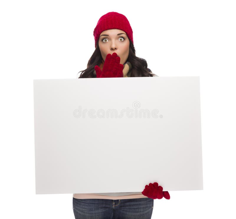 Cappello d'uso di inverno della ragazza sgomento e segno in bianco delle tenute dei guanti fotografia stock Cappello d'uso di inverno della ragazza sgomento e segno in bianco delle tenute dei guanti fotografia stock