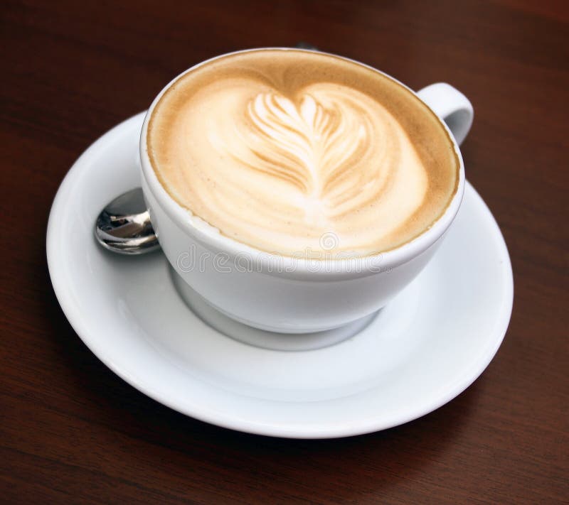 Un cappuccino in una ciotola sul tavolo di legno.