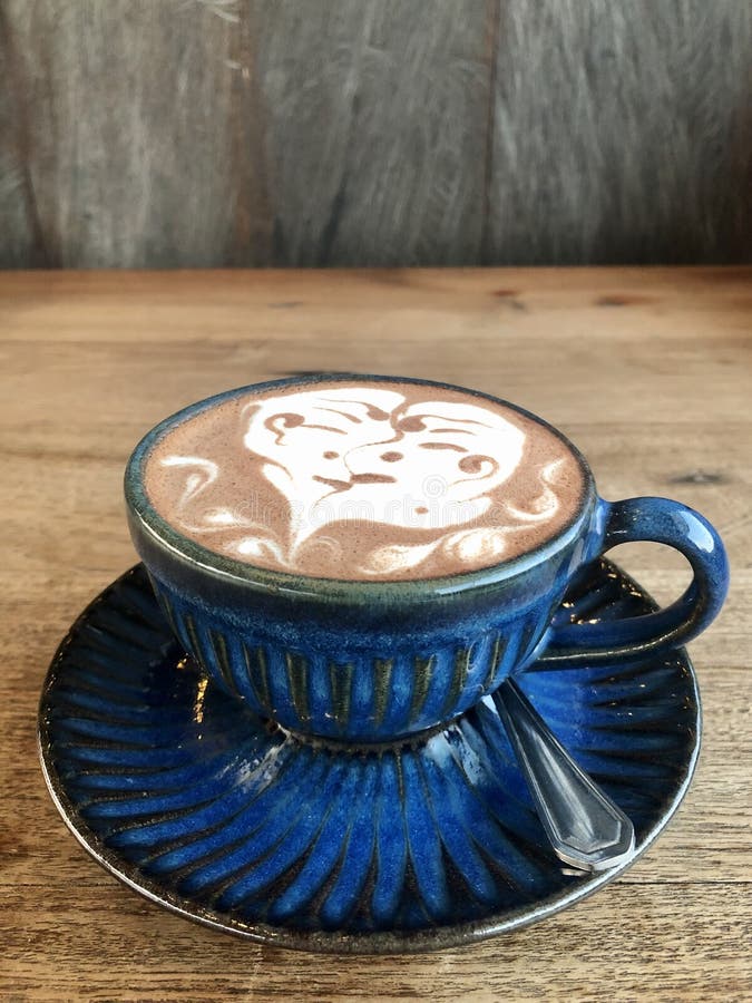 Cappuccino kiss. Blue cup set. Wooden table