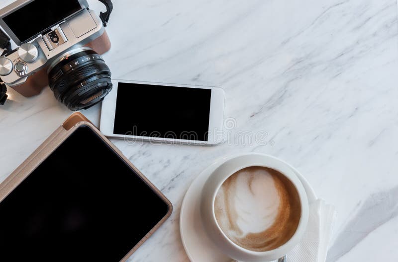 Cappucino, таблетка, телефон и камера на белой таблице стоковые изображения Cappucino, таблетка, телефон и камера на белой таблице стоковые изображения