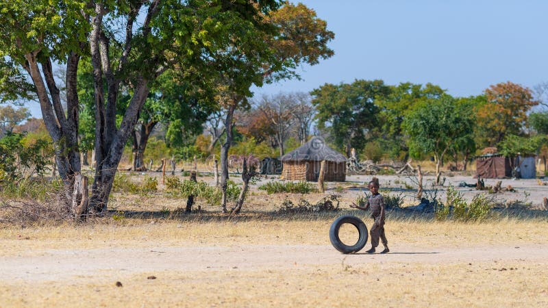 Caprivi, Namibia - August 20, 2016: Poor teenager playing on the roadside in the rural Caprivi Strip, the most populated region in Namibia, Africa. Caprivi, Namibia - August 20, 2016: Poor teenager playing on the roadside in the rural Caprivi Strip, the most populated region in Namibia, Africa.