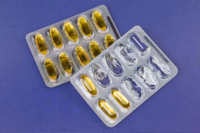 Capsules jaunes dans la vue de dessus de l'emballage de blister commencée et entière photos stock