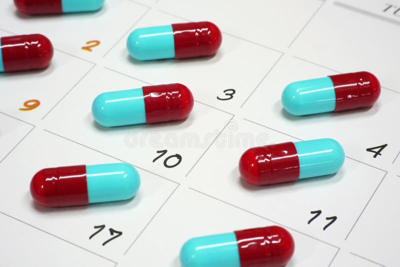 Capsules rouges et bleues sur le calendrier image libre de droits Capsules rouges et bleues sur le calendrier image libre de droits