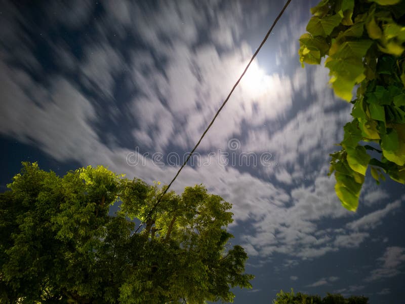 A captivating night scene featuring clouds in motion and a bright moon illuminating the peaceful darkness royalty free stock photo