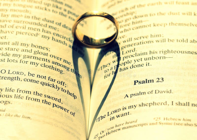 Captura de pantalla de un anillo de boda en la Biblia haciendo una hermosa ilustración del corazón fotografía de archivo Captura de pantalla de un anillo de boda en la Biblia haciendo una hermosa ilustración del corazón fotografía de archivo