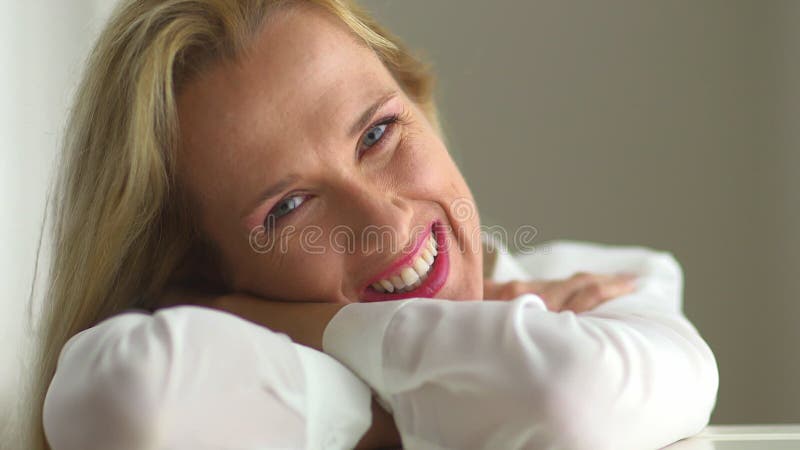 Captura de pantalla de una mujer madura sonriente abriendo los ojos almacen de metraje de vídeo