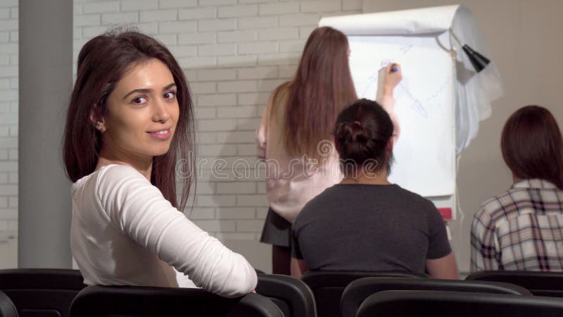 Captura de vista trasera de una mujer de negocios escuchando a un orador en una conferencia de negocios fotografía de archivo libre de regalías Captura de vista trasera de una mujer de negocios escuchando a un orador en una conferencia de negocios fotografía de archivo libre de regalías