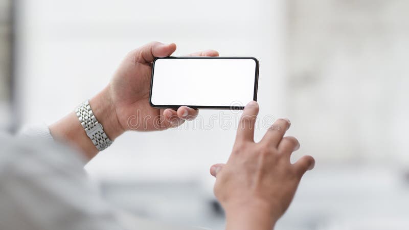 Captura recortada de un hombre de negocios tocando un smartphone horizontal en pantalla en blanco con una oficina borrosa