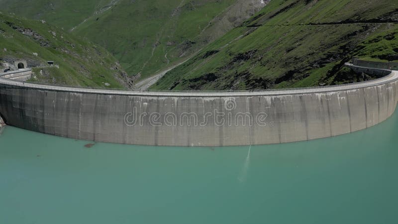 Capture de drone d'eaux turquoise derrière le barrage de Mooserboden dans les hautes terres accidentées banque de vidéos