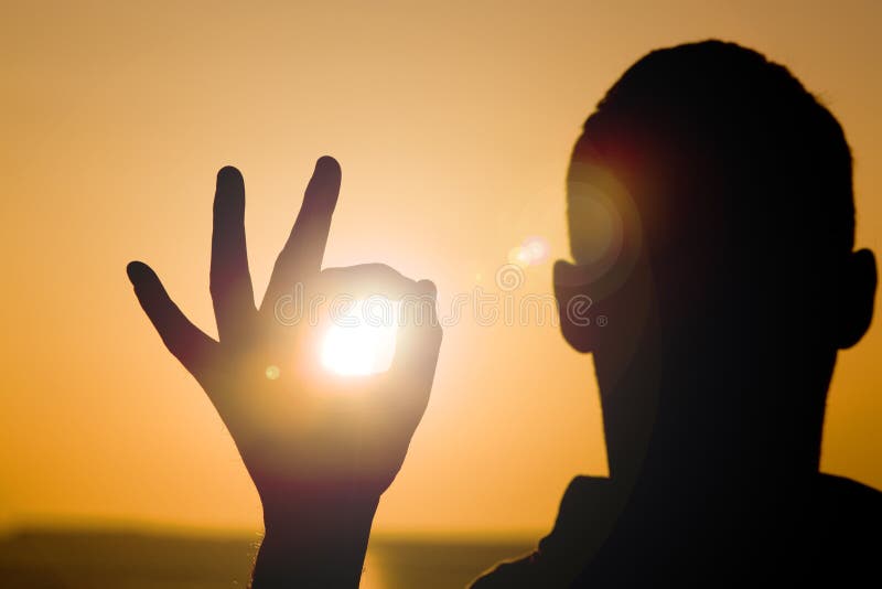 A person holding the sun in his hand. A person holding the sun in his hand