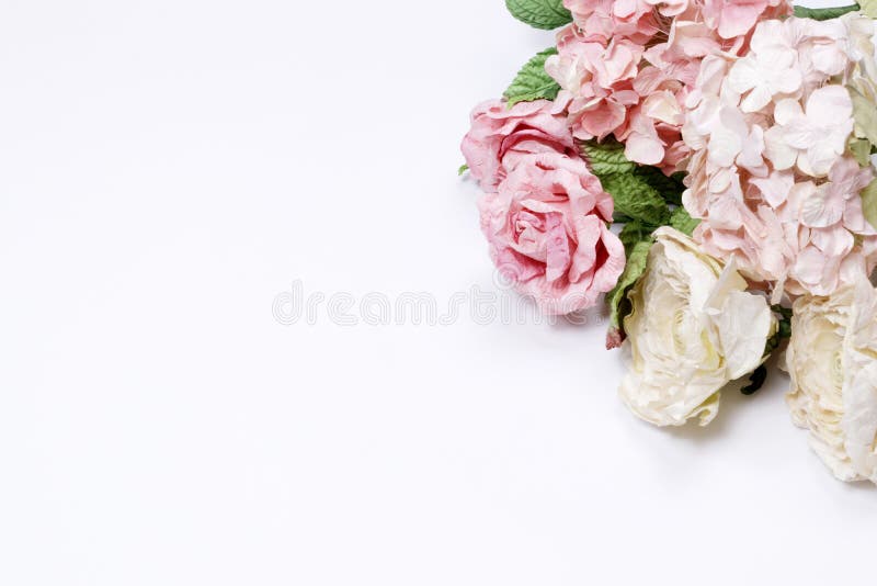 Frame made of pink and beige roses, green leaves, blue hydrangea, branches on white background. Flat lay, top view. Wedding`s background. Valentine`s background with copy space. Frame made of pink and beige roses, green leaves, blue hydrangea, branches on white background. Flat lay, top view. Wedding`s background. Valentine`s background with copy space.