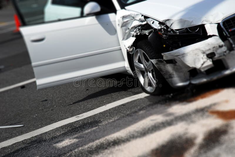 Una macchina bianca e dopo l'incidente con materiale assorbente sulla strada prendendo l'auto fluidi.