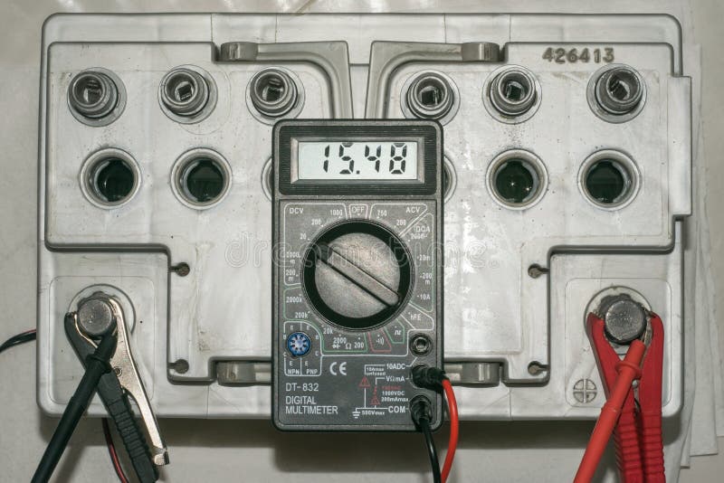 Car Battery Charging. Gray Battery with Caps Unscrewed Charger Cables