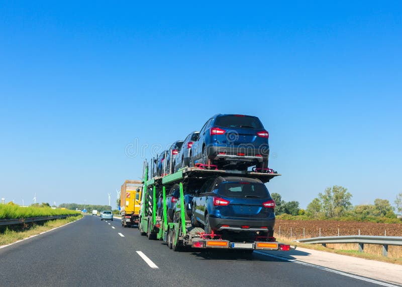 Car carrier trailer with cars on bunk platform. Car transport truck on the highway. Space for text royalty free stock image Car carrier trailer with cars on bunk platform. Car transport truck on the highway. Space for text royalty free stock image