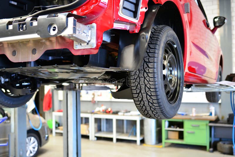 Car for changing tyres on a lifting platform in the workshop- closeup profile of a tyre stock photos