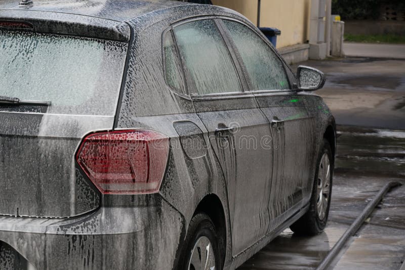 Car Covered by Active Foam during Car Washing Entering the Brushes of a