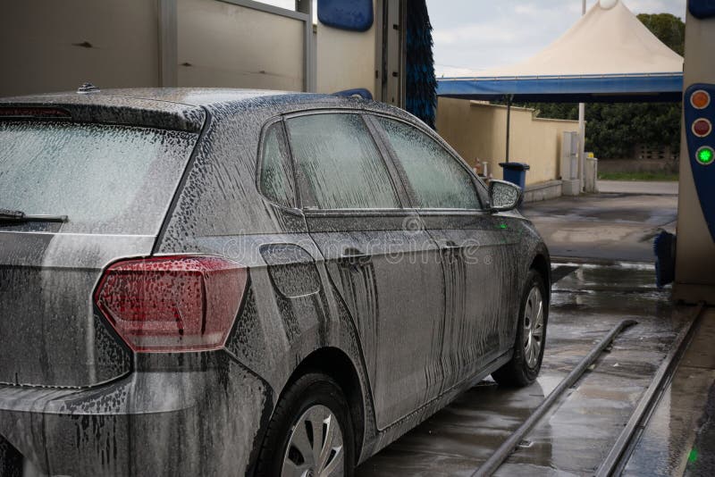 Car Covered by Active Foam during Car Washing Entering the Brushes of a