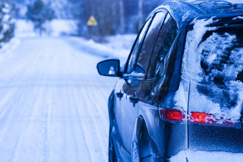 Car covered with snow on a dangerous road.