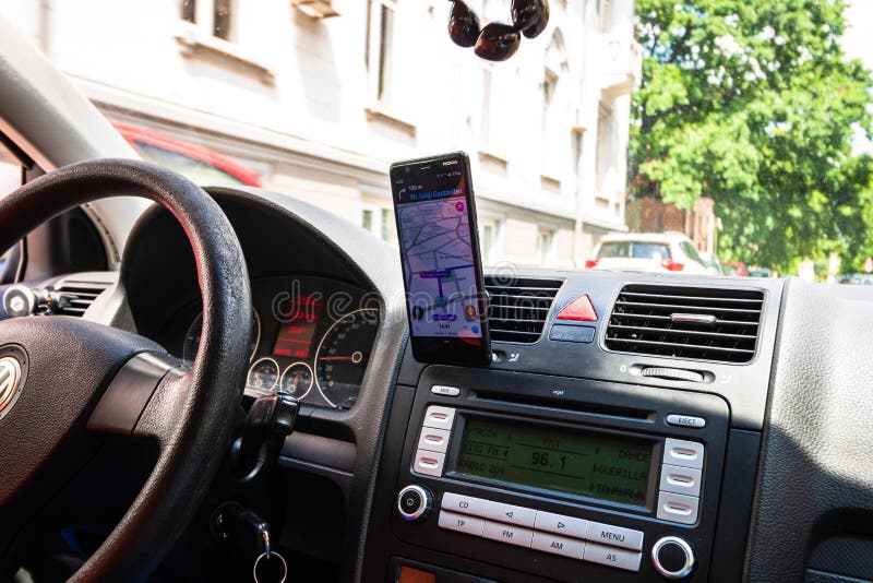 In Car Dashboard View with Smartphone on Waze Maps. Driver Using Waze