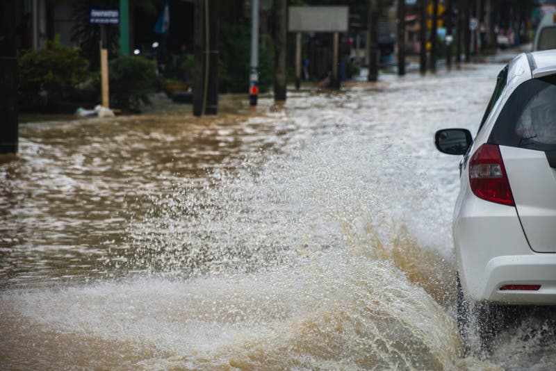 Car driving on flooded road with Flood water flow through the road after heavy winds and storm surges royalty free stock photos Car driving on flooded road with Flood water flow through the road after heavy winds and storm surges royalty free stock photos