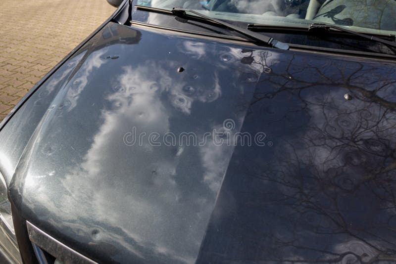 Car engine hood with many hail damage dents show the forces of nature and the importance of car insurance and a replacement value stock photo Car engine hood with many hail damage dents show the forces of nature and the importance of car insurance and a replacement value stock photo