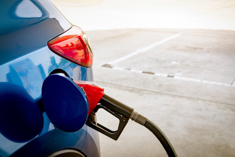 Car fueling at gas station. Refuel fill up with petrol gasoline. Petrol pump filling fuel nozzle in fuel tank of car at gas