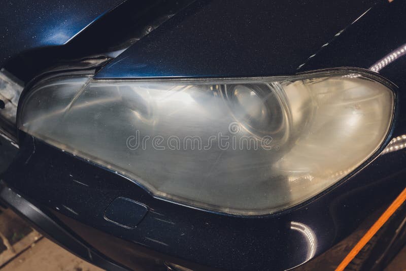 Car Headlights Cleaning with Power Buffer Machine at Car Service. Stock