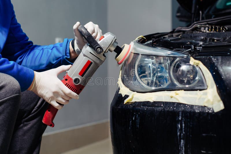 Car Headlights Cleaning with Power Buffer Machine at Car Service Stock