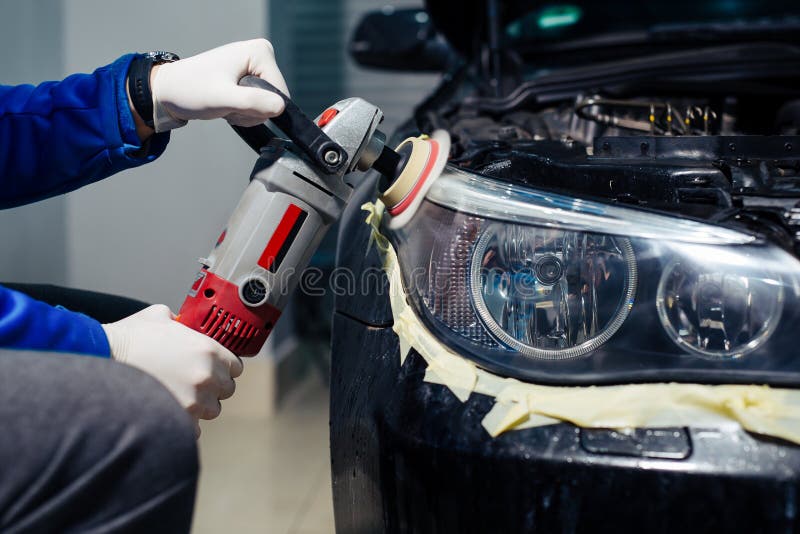 Car Headlights Cleaning with Power Buffer Machine at Car Service Stock