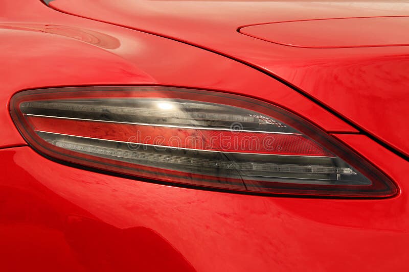 Car Headlights. Luxury Headlights. Part of a Red Car Close Up Stock