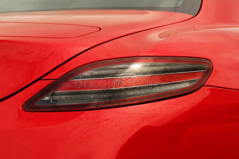 Car Headlights. Luxury Headlights. Part of a Red Car Close Up Stock