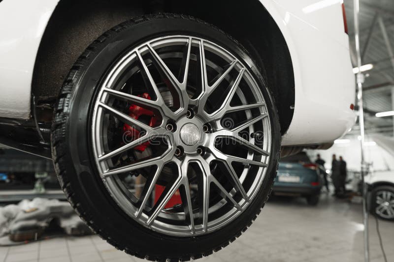 Car on a Hoist in Repair with Focus on the Wheel Stock Image