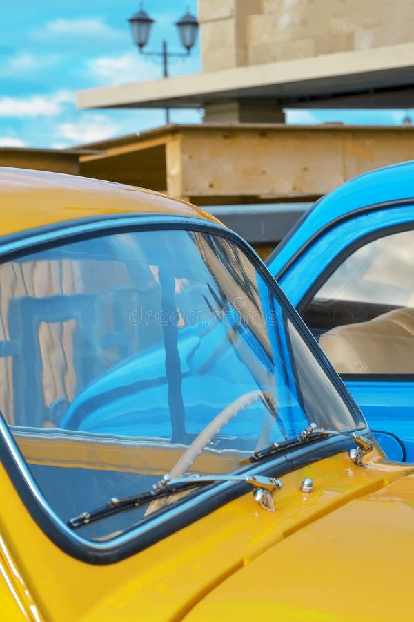 Car Hood and Windshield of a Yellow Car on the Background of a Blue Car