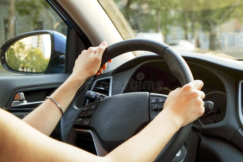 Car interior with female driver sitting behind the wheel, soft sunset light. Luxurious vehicle dashboard and electronics. royalty free stock images Car interior with female driver sitting behind the wheel, soft sunset light. Luxurious vehicle dashboard and electronics. royalty free stock images