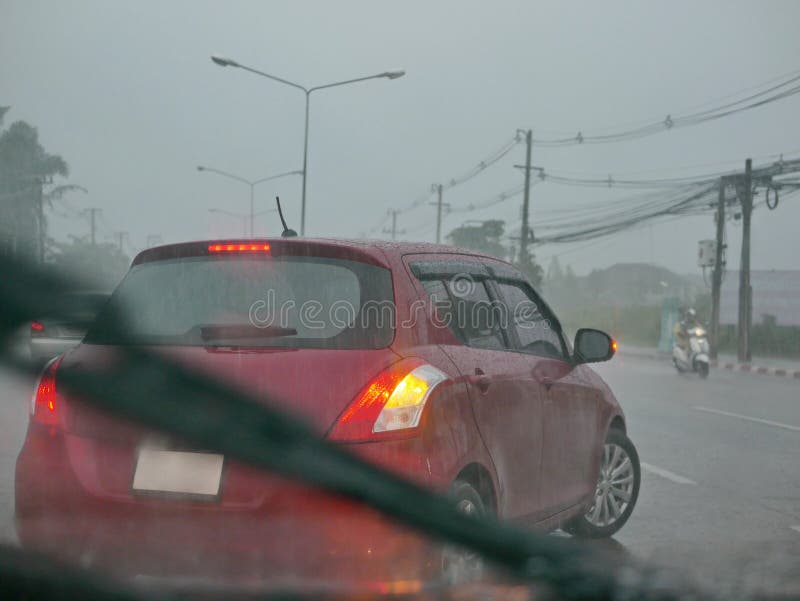 A car with its signal light on is carefully making a U-turn in a heavy rain on a rainy day. - driver`s perspective from another car behind. A car with its signal light on is carefully making a U-turn in a heavy rain on a rainy day. - driver`s perspective from another car behind