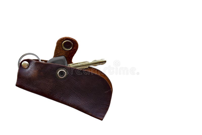 The car key is placed in a cow leather case. small brown handbag for key isolated on white background. The car key is placed in a cow leather case. small brown handbag for key isolated on white background.