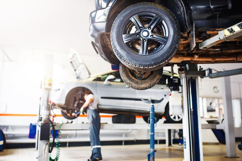 The Car is Lifted for Repair on a Lift in a Car Service Station, a