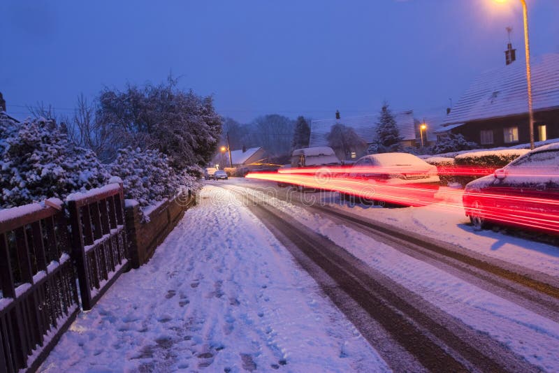 Car lights streaming by on a snowy evening