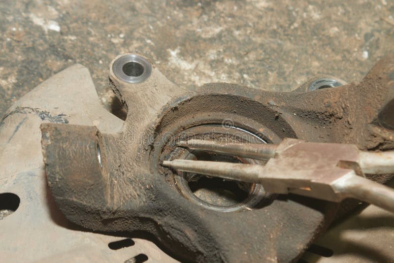 Car Mechanic or Auto Mechanic Use Pliers for Wheel Bearings Lock Ring Removal Stock Photo