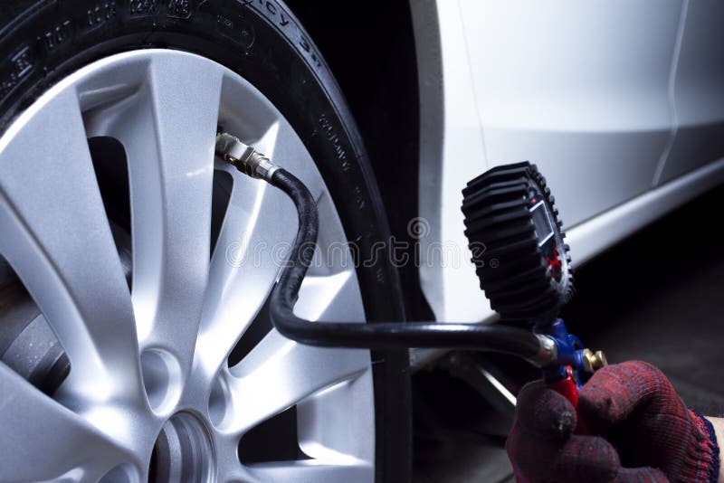 Car mechanic checks tire pressure. royalty free stock photography