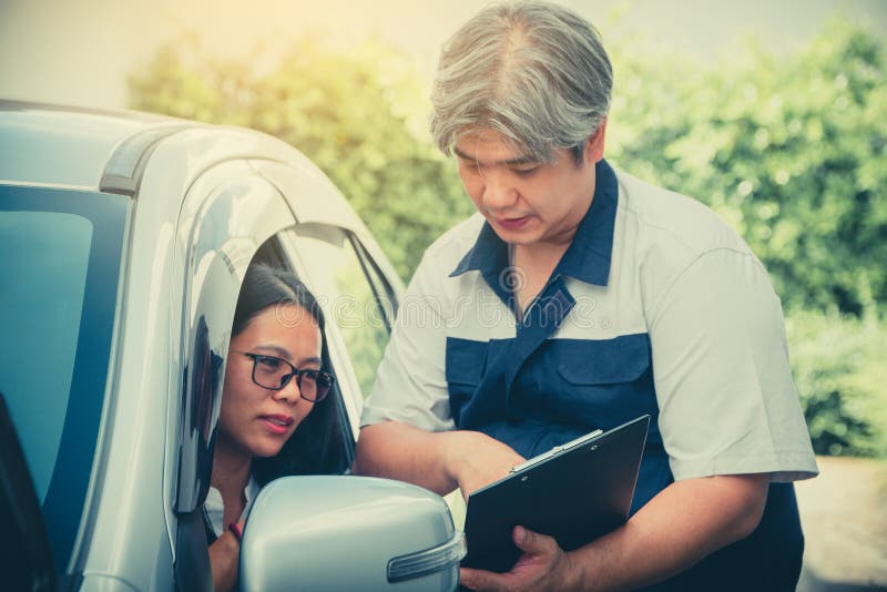 The car mechanic is describing the details of the car inspection. For women who own For understanding before repairing royalty free stock image The car mechanic is describing the details of the car inspection. For women who own For understanding before repairing royalty free stock image