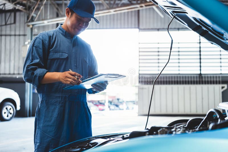 Car Mechanic Holding Clipboard And Checking To Maintenance Vehicle By