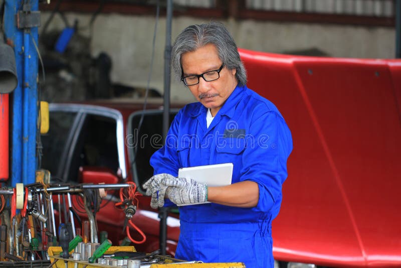 Closeup of Car Mechanic Working Under Car in Auto Repair Service